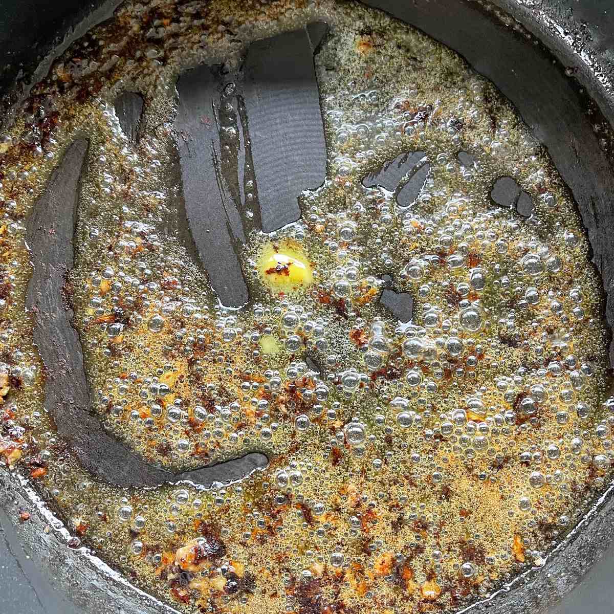 Melted butter in a frypan once the meatballs have been removed from the pan.