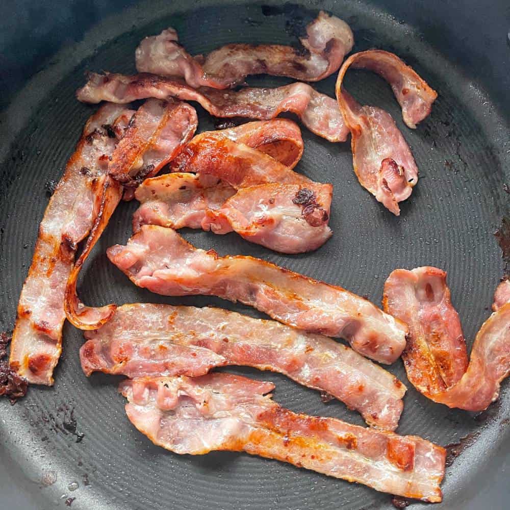 Bacon cooking in a frying pan.