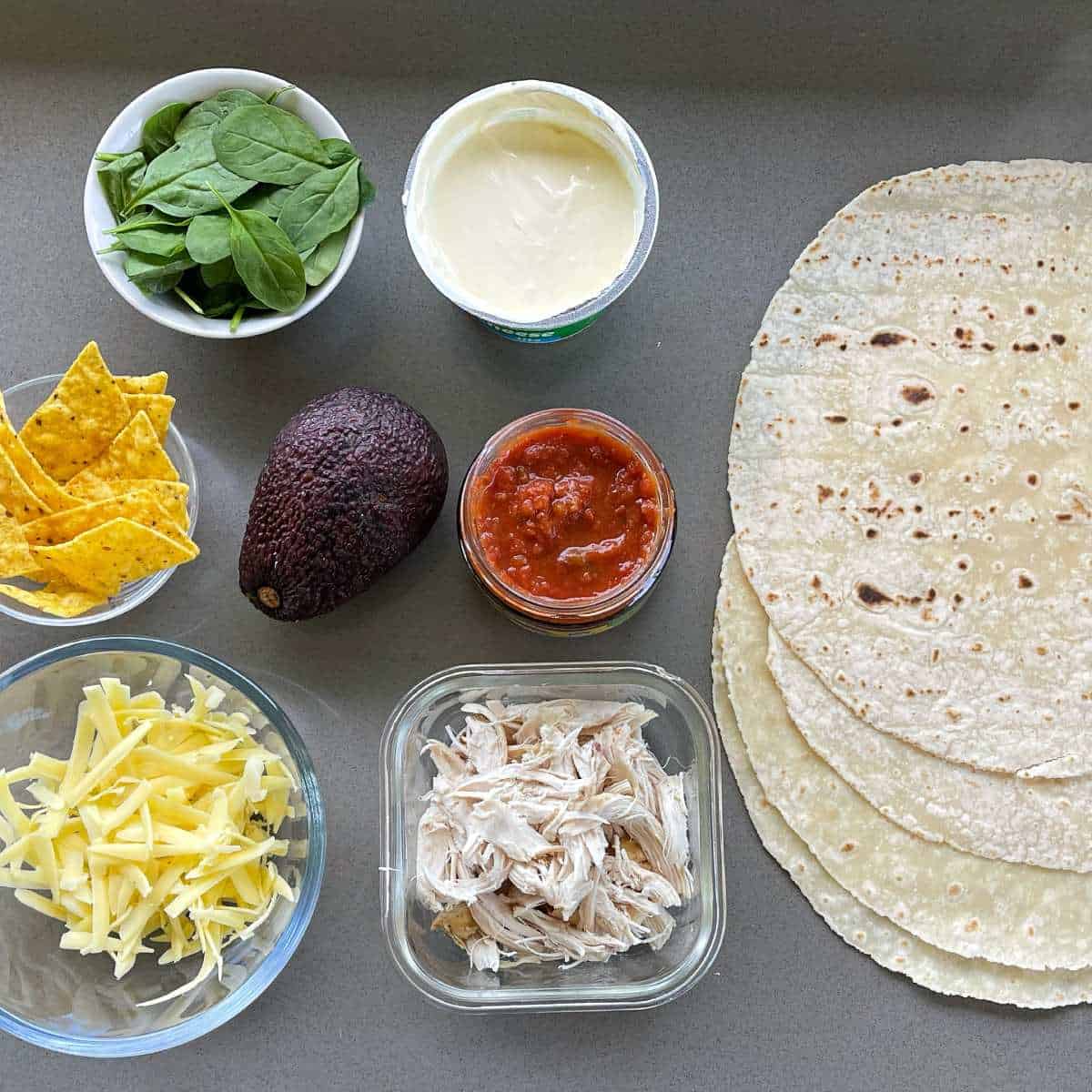 The ingredients for Chicken Tortillas on a grey bench.