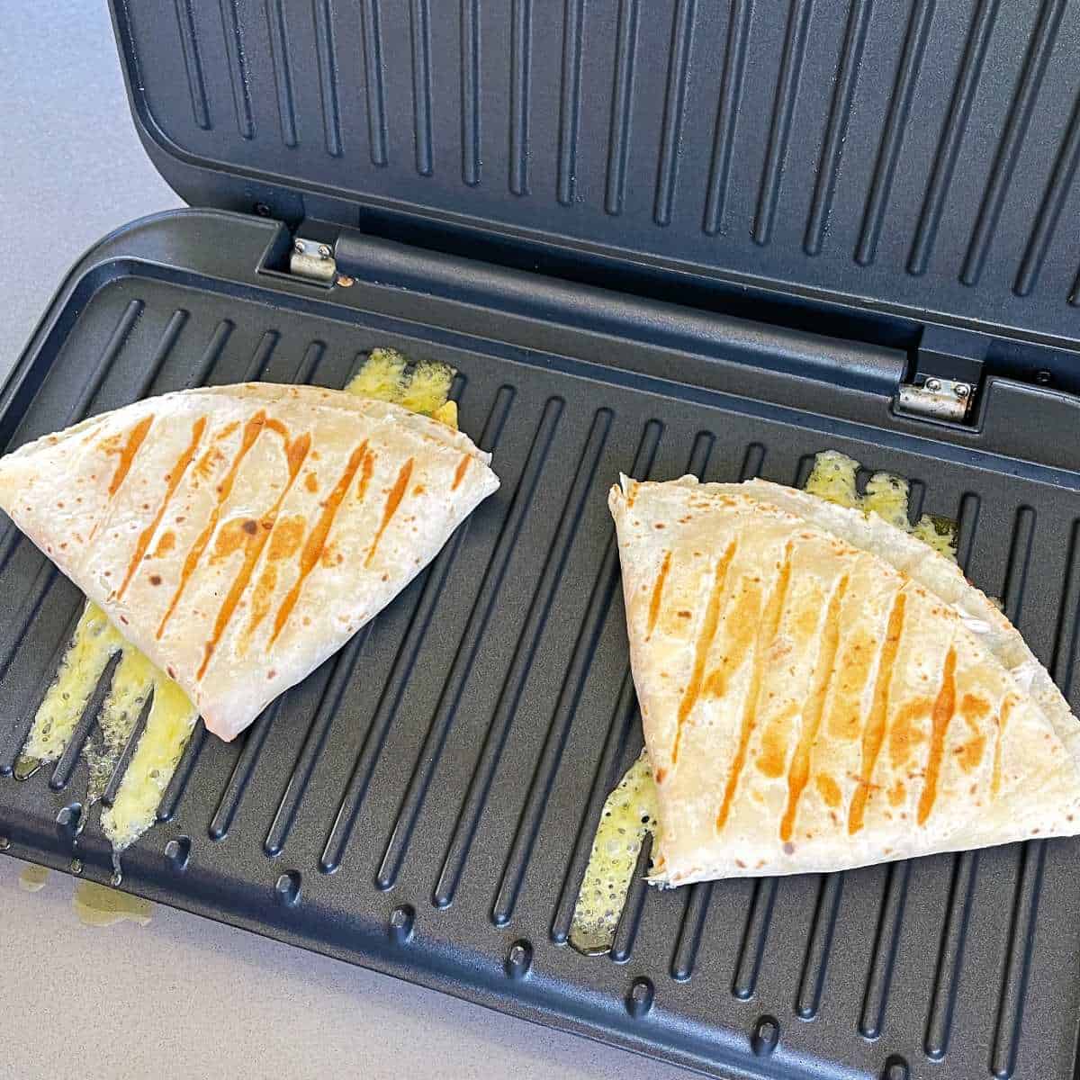 Two Chicken Tortillas toasting on a toasted sandwich maker