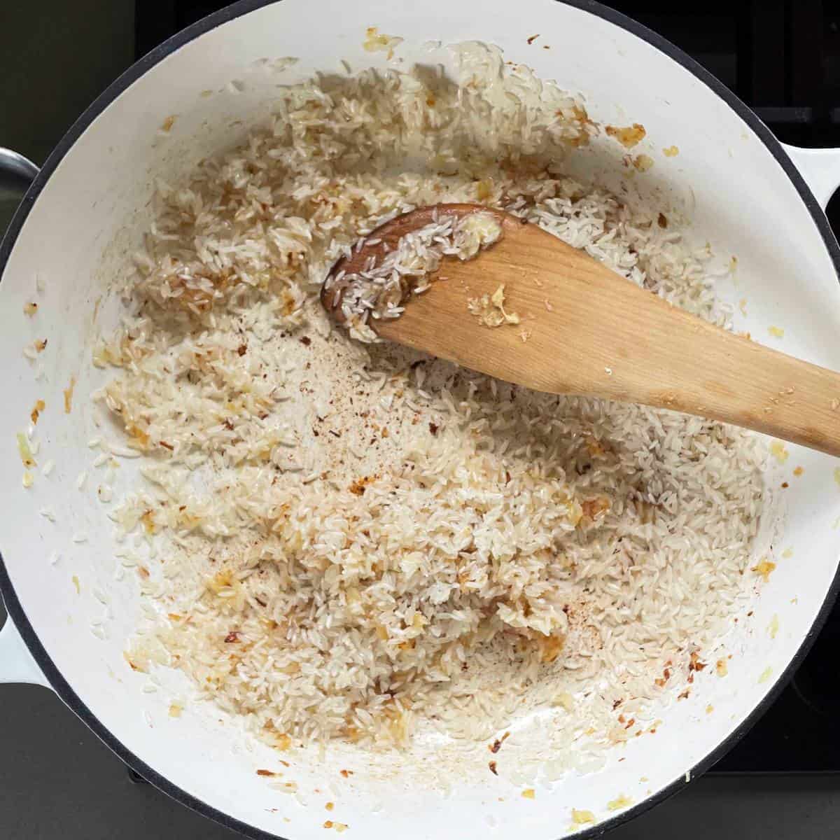 Rice and onion cooking in a pan.
