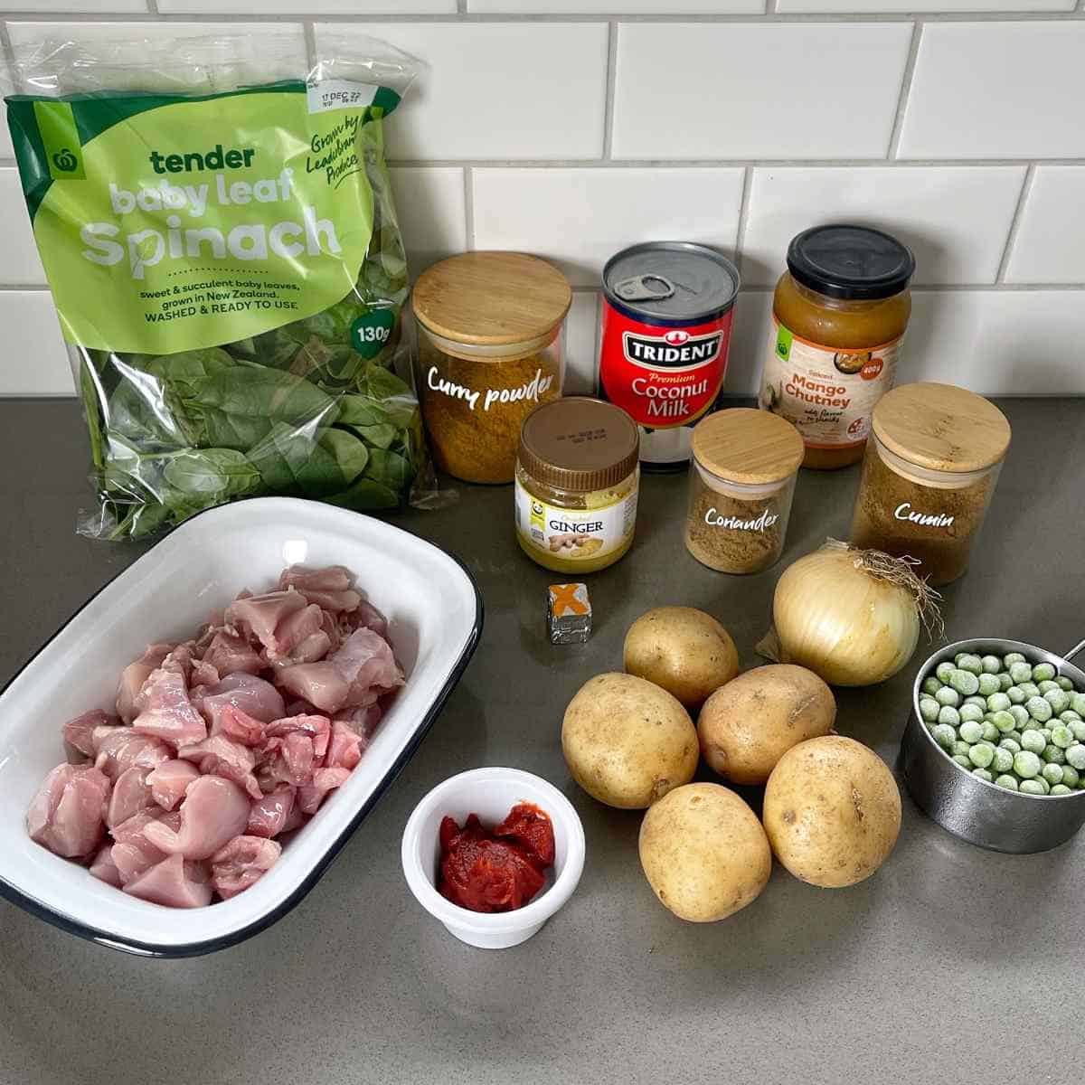 The ingredients for Chicken and Potato Curry on a grey bench.