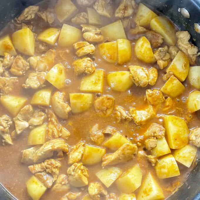 Chicken and Potato curry cooking in a frypan, before the green vegetables have been added.