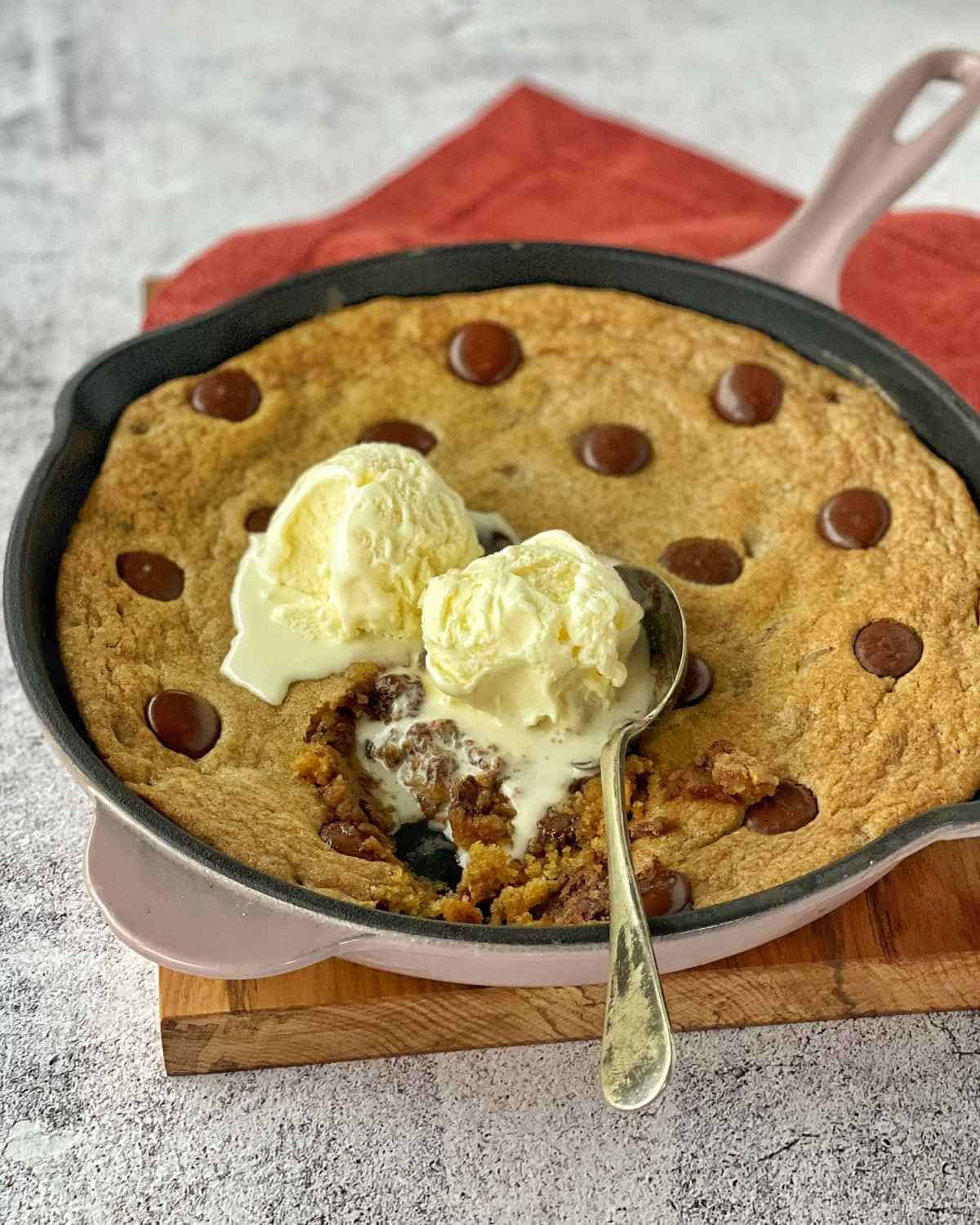 Cooked Chocolate Chip Skillet Cookie served with vanilla ice-cream.