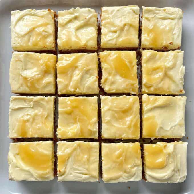 A set lemon curd no bake cheesecake sliced into even portions sitting on a white platter.
