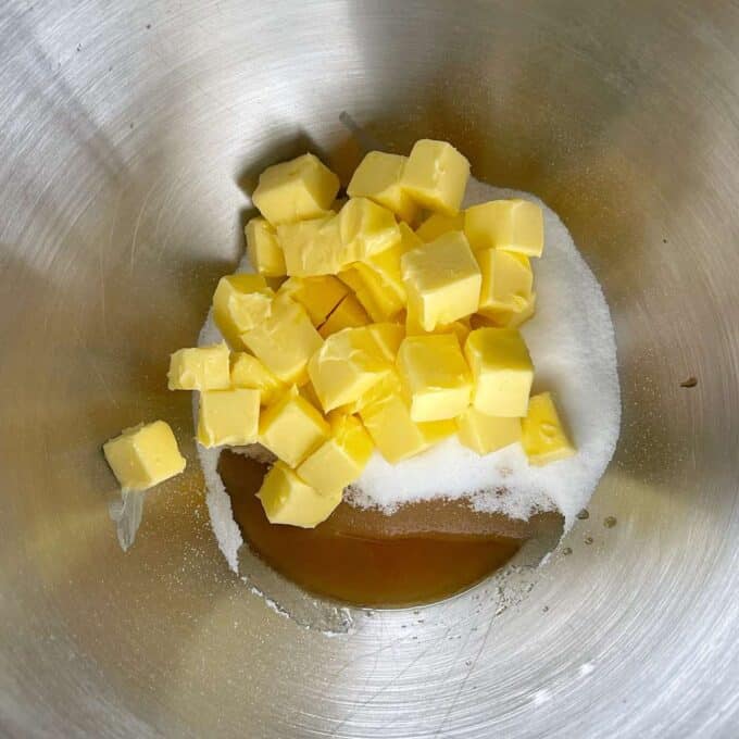Cubed butter, sugar and vanilla essence in a mixing bowl before being combined together.