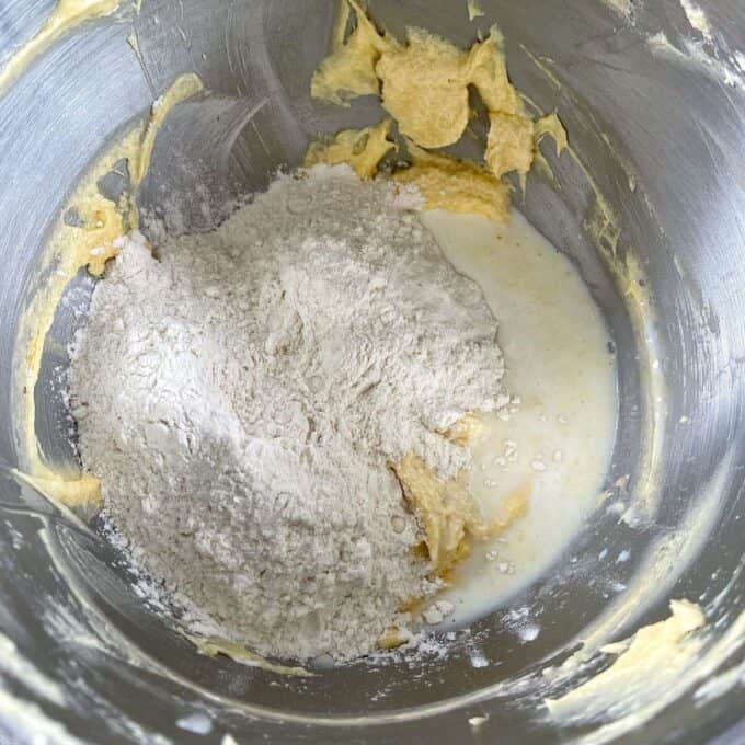 Flour and milk being added to the creamed butter and sugar mixture for the classic vanilla cupcakes.