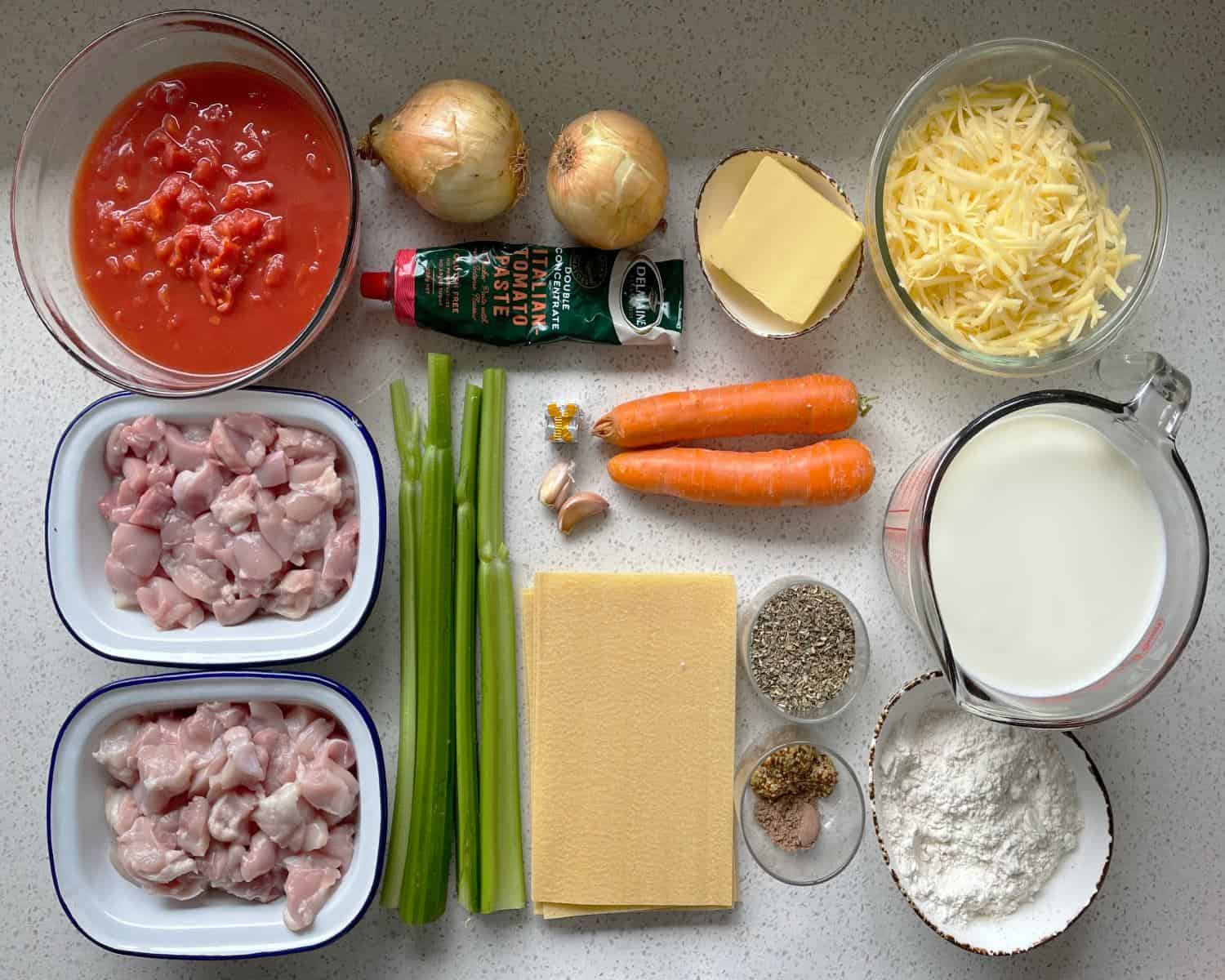 The ingredients for Chicken Lasagne on a white bench.