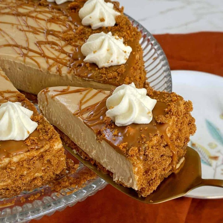 A close up shot of one slice being removed from the set Biscoff Cheesecake.