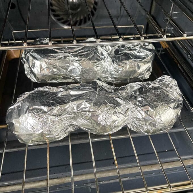 Wrapped potatoes in tinfoil cooking in the oven.