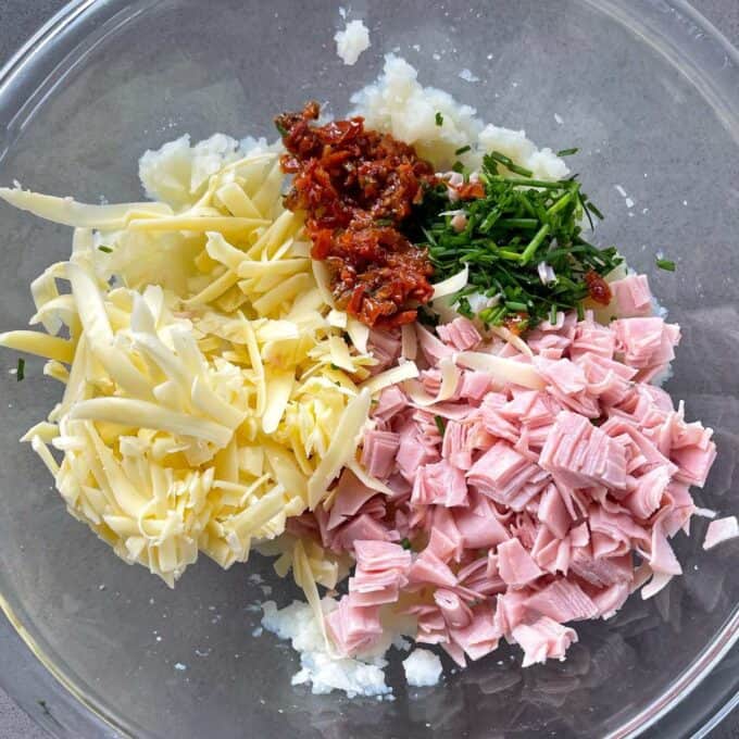 All of the ingredients for the filling of Jacket Potatoes in a glass bowl before being combined together.