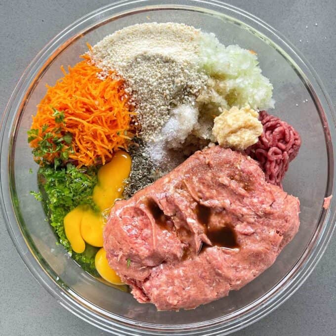 All of the ingredients to make the meat for the Meatloaf in a glass bowl before being combined together.