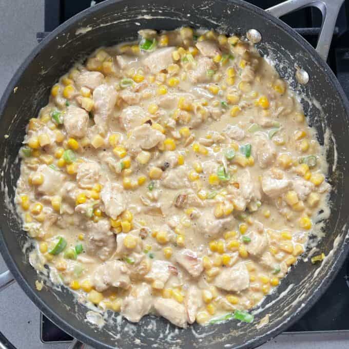 The filling for chicken and sweetcorn pies cooking in a frying pan.