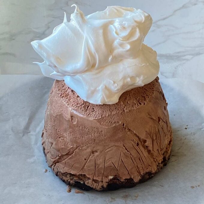 Chocolate ice cream being covered with meringue to be made into a baked alaska.