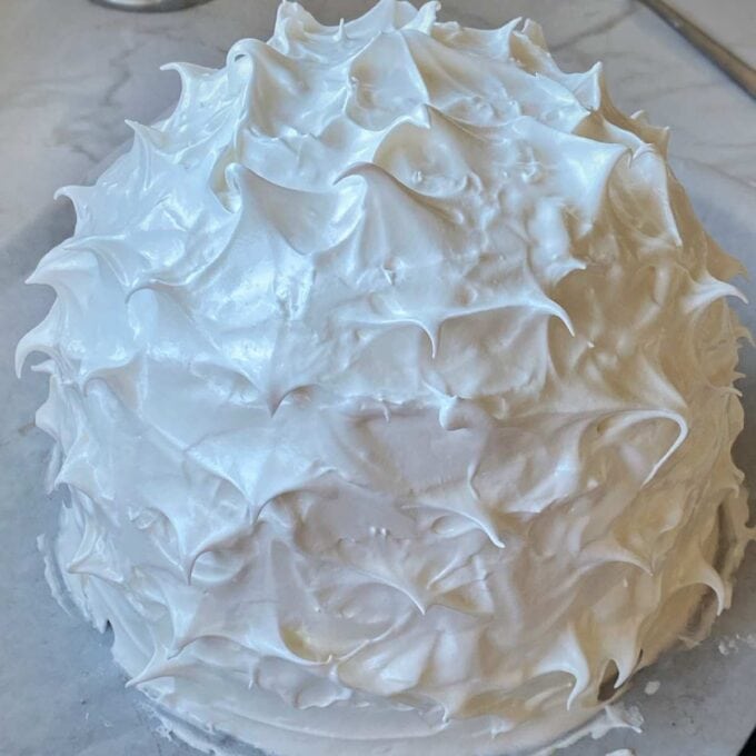 A baked Alaska sitting on a baking tray before it gets baked in the oven.