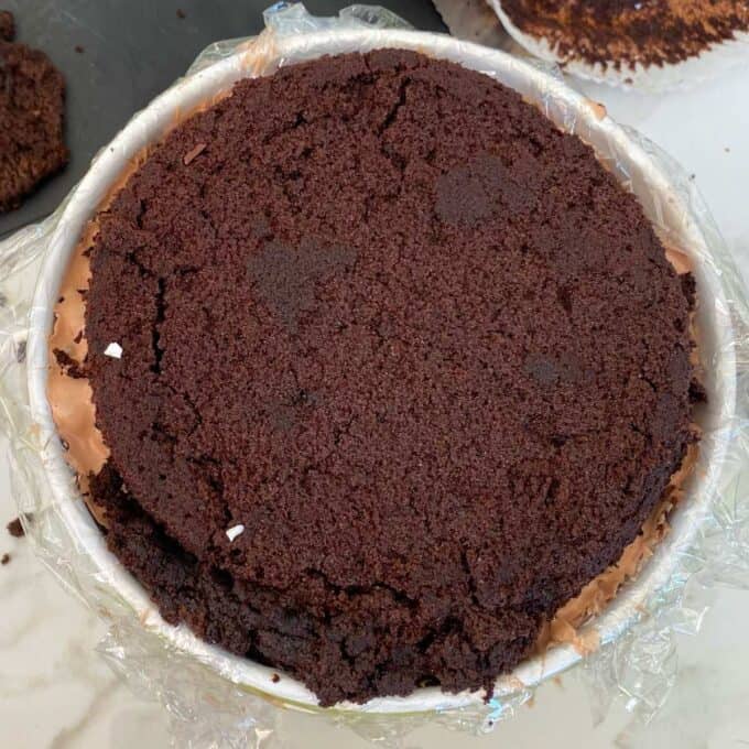 A bowl filled with ice cream and chocolate cake on a marble bench.