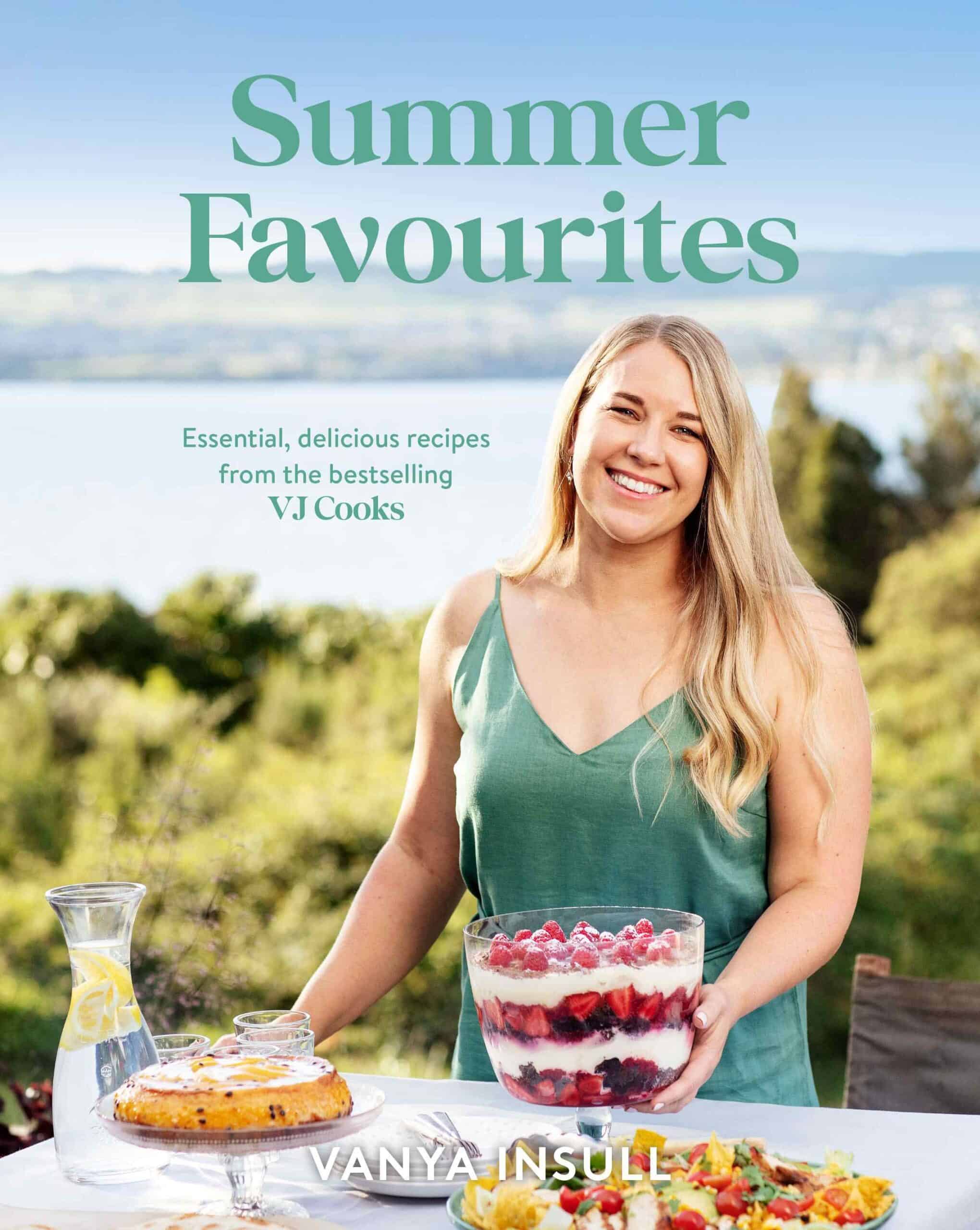A woman stands outdoors at a table set with Summer Favourites, holding a trifle dessert. The text reads Summer Favourites by Vanya Insull.