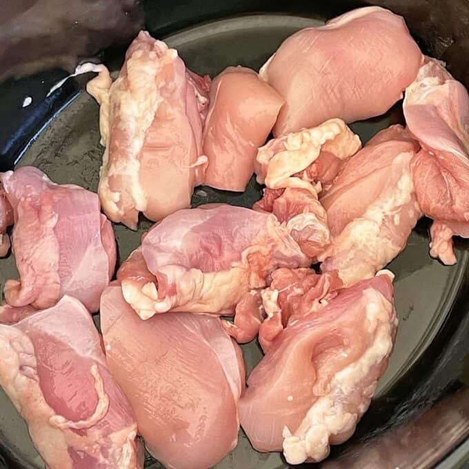 Sliced chicken pieces in a crockpot.