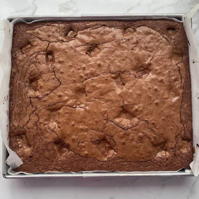 Cooked brownie in a lined baking tin.