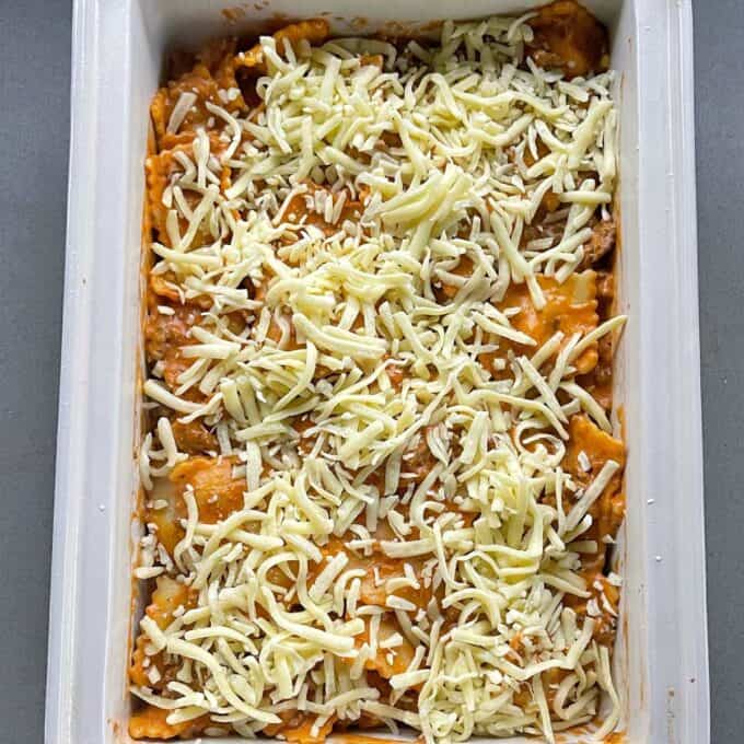 The combined mince and tortelini mixture in a oven dish with grated cheese scattered over the top before being baked in the oven.