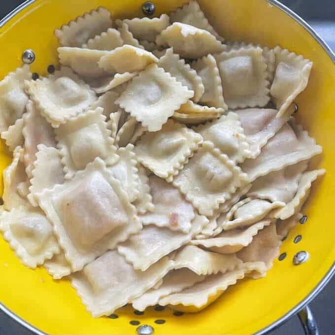 Strained cooked tortelini in a colander.