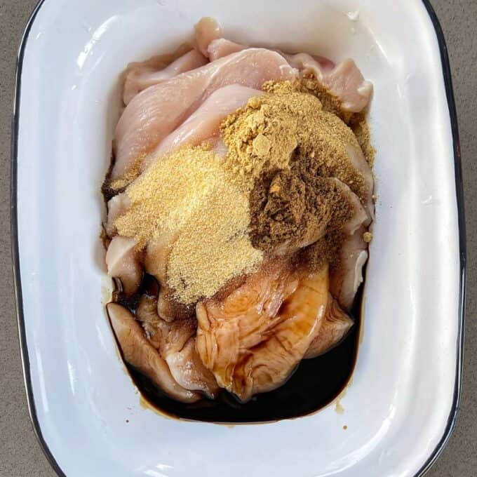 Diced chicken, spices and soy sauce in a small dish before being mixed through to marinate.
