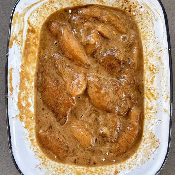 Marinated chicken sitting in a small dish