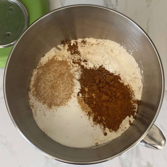 The dry ingredients in a mixing bowl to make hot cross buns.