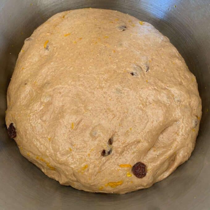 The dough to make hot cross buns in a mixing bowl.