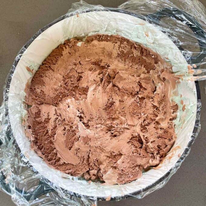 Chocolate ice cream in the base of a cast iron dish lined with cling film.