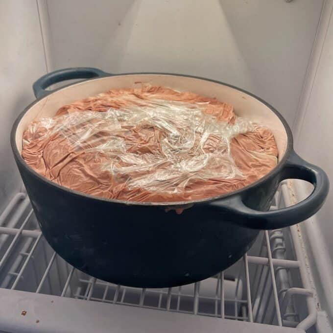 An ice cream cake in a cast iron dish chilling in the freezer.