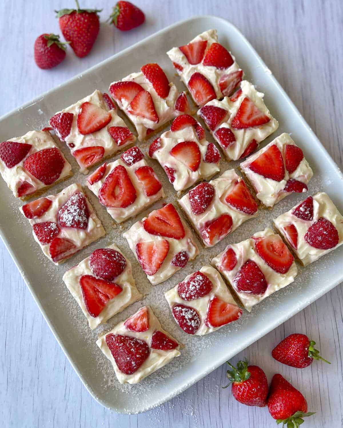 A close up of pieces of strawberry cheesecake slice on a white plate.