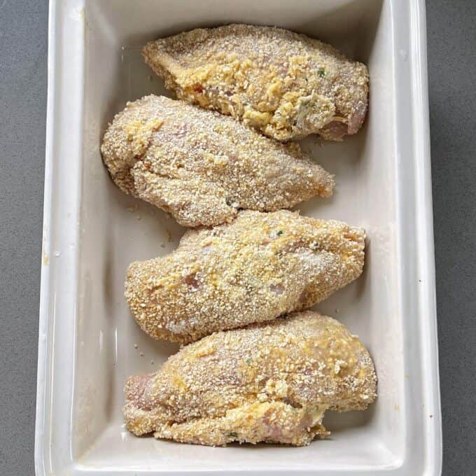 4 crumbed chicken breasts in a roasting dish.