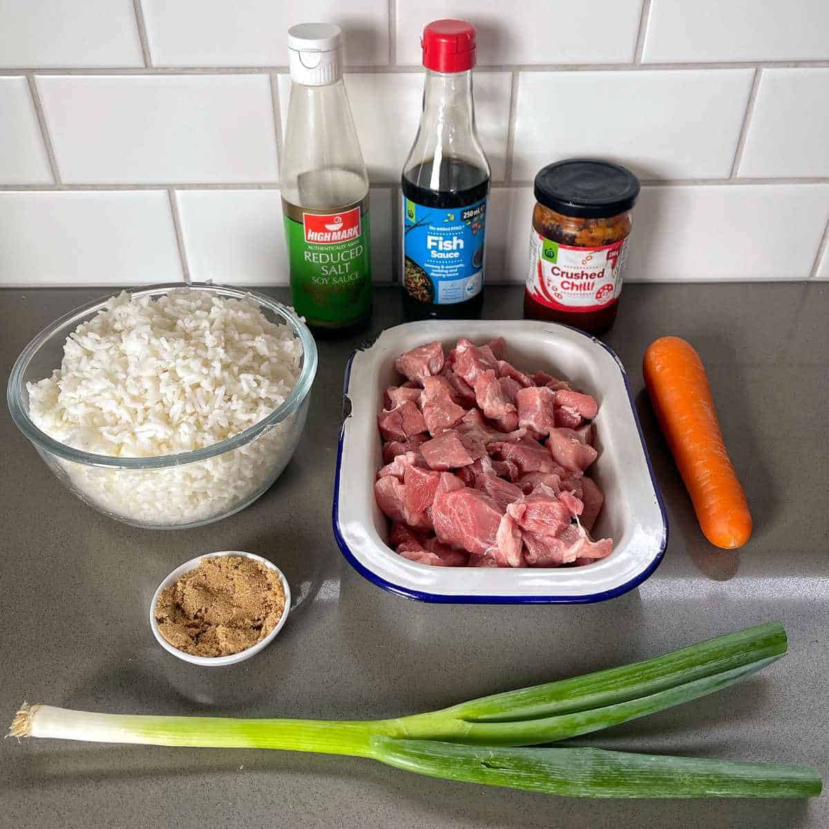 The ingredients for Nasi Goreng Pork on a grey bench top.
