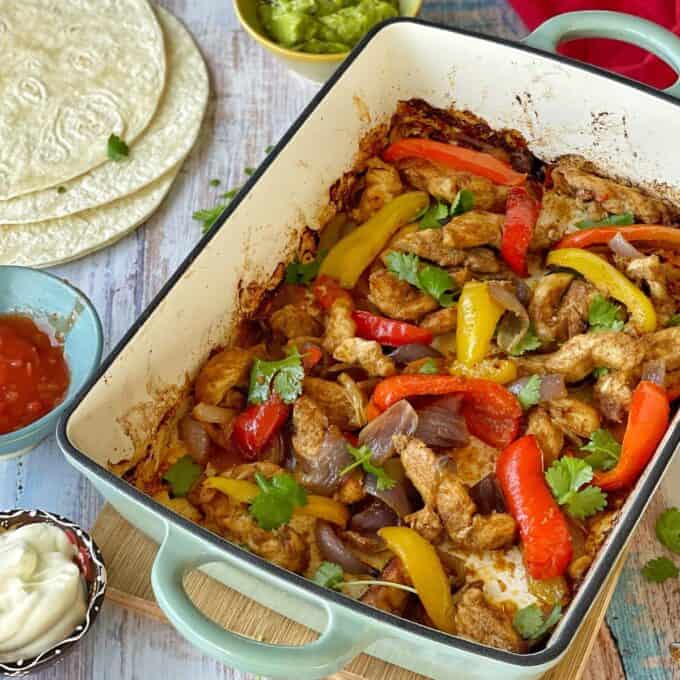 All of the roasted marinated vegetables and chicken for Chicken Fijita's in a oven proof dish. Coriander leaves have been scattered over the top.