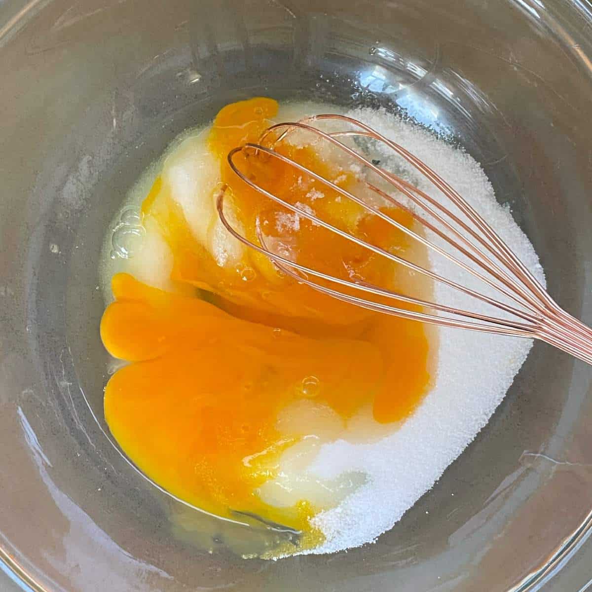 Sugar and eggs in a glass bowl.