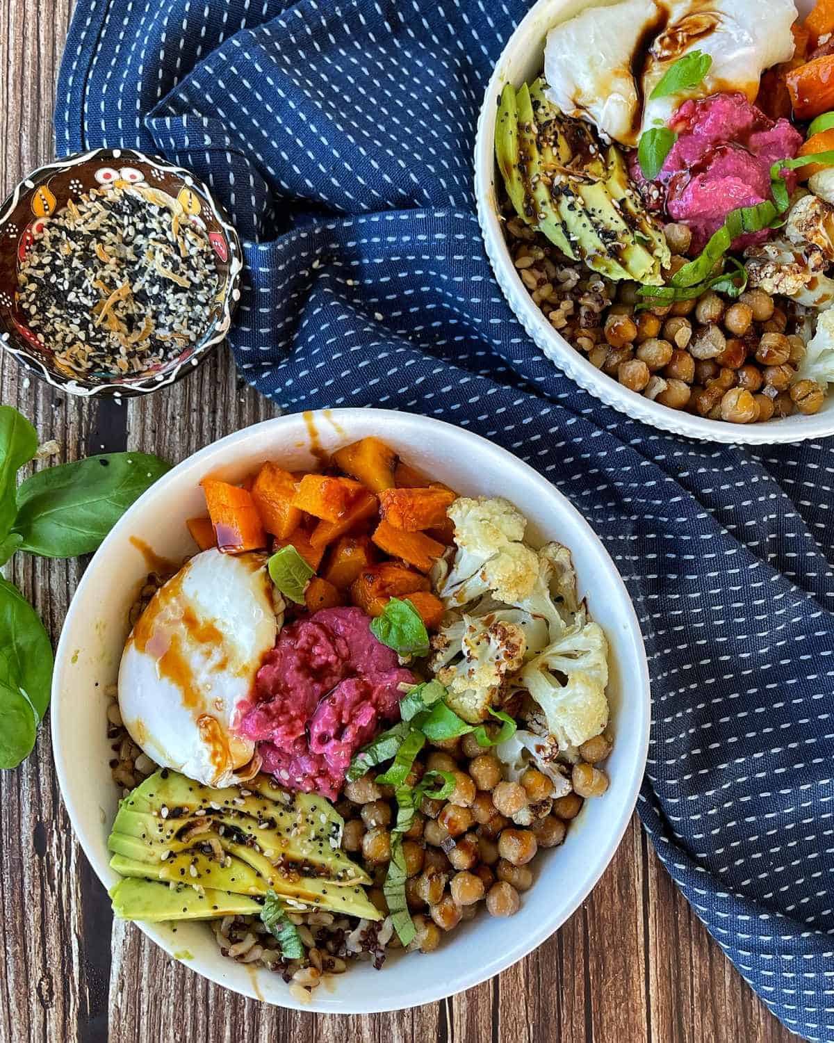 A close up of a cooked and assembled Nourish Bowl on a wooden table.