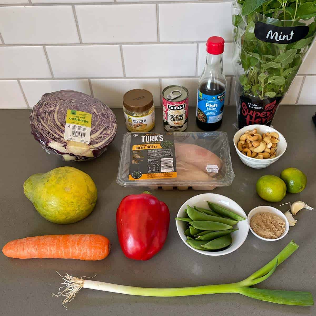 The ingredients to make Thai Style Chicken Slaw sitting on a grey bench top