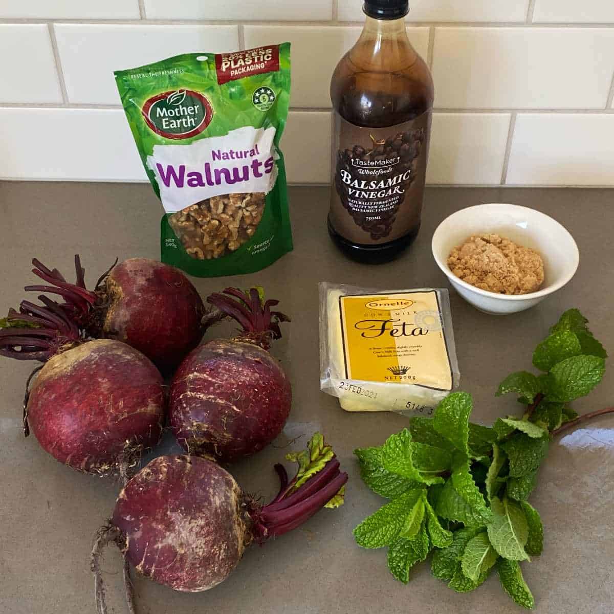 The ingredients to make Beetroot, Feta and Walnut Salad sitting on a grey bench top