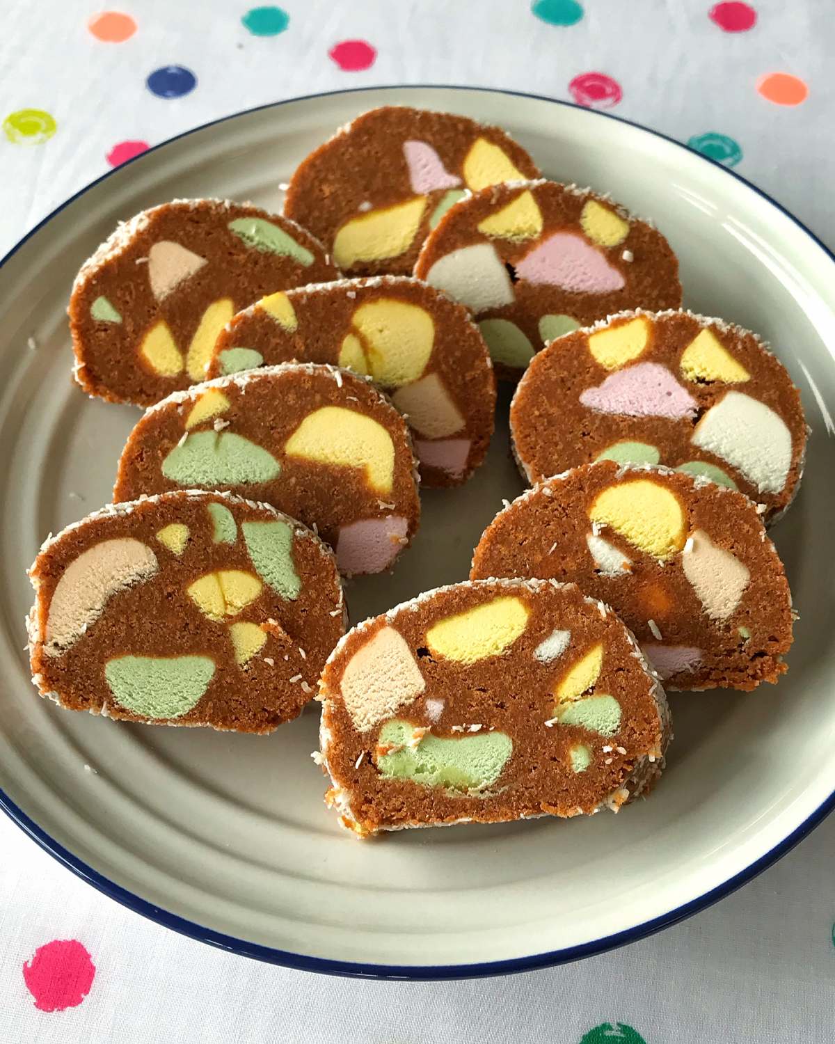 A plate with several slices of chocolate biscuit and marshmallow dessert, each piece showing colorful marshmallow chunks inside—classic Lolly cake at its best.