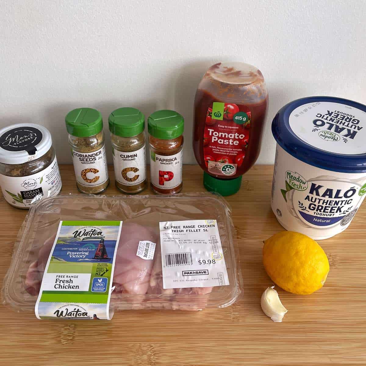 The ingredients to make air fryer tandoori chicken flatbreads on a wooden bench top