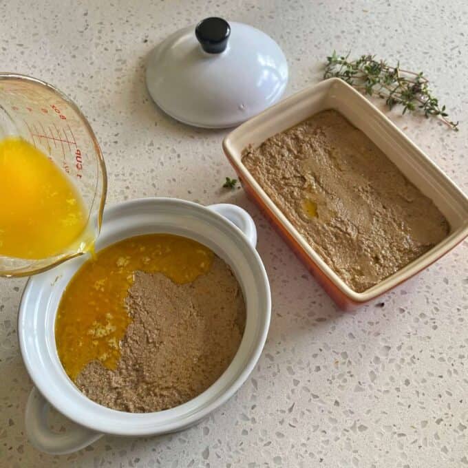 Melted butter being poured over cooked chicken liver pate in ramekins