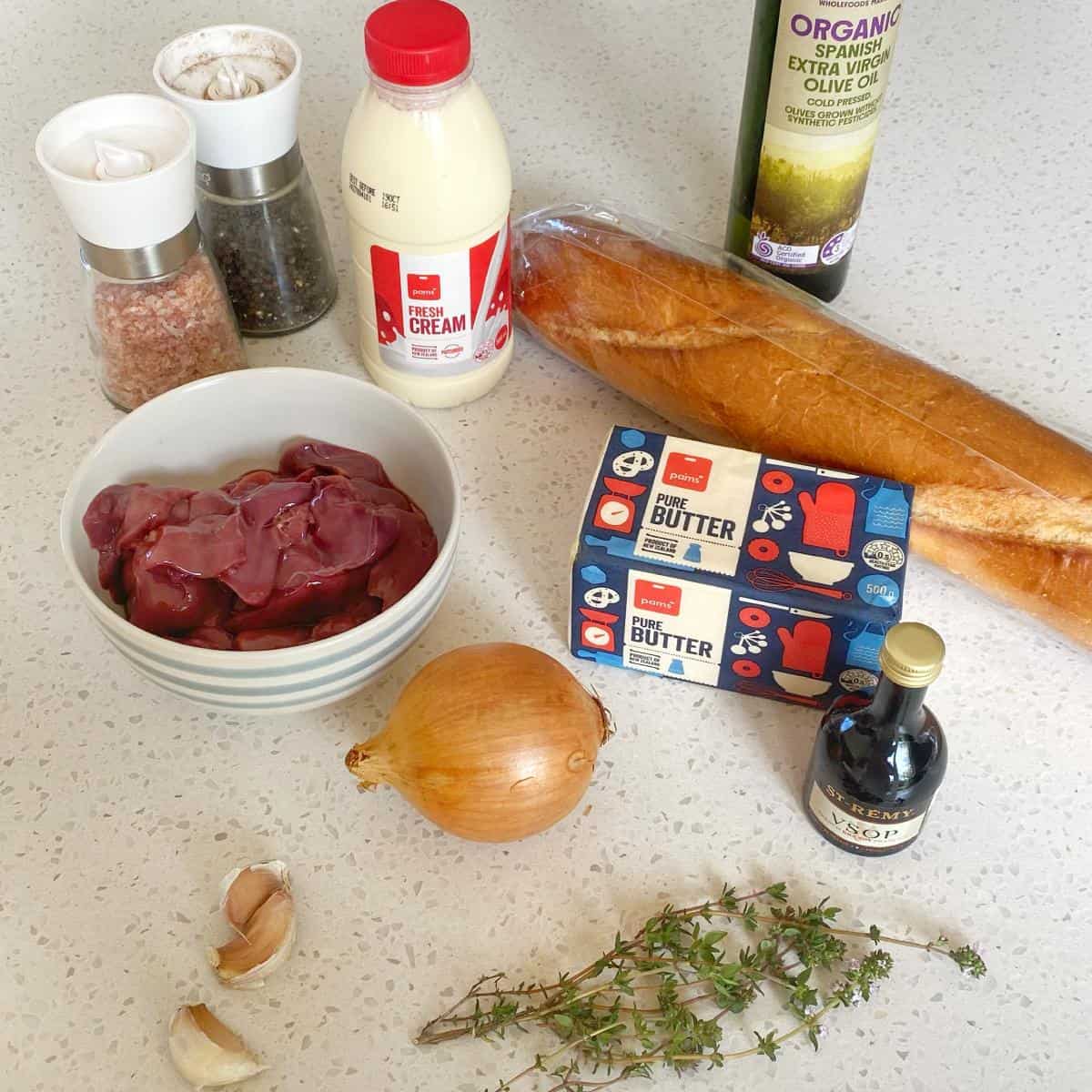 The ingredients to make chicken liver pate on a marble bench top