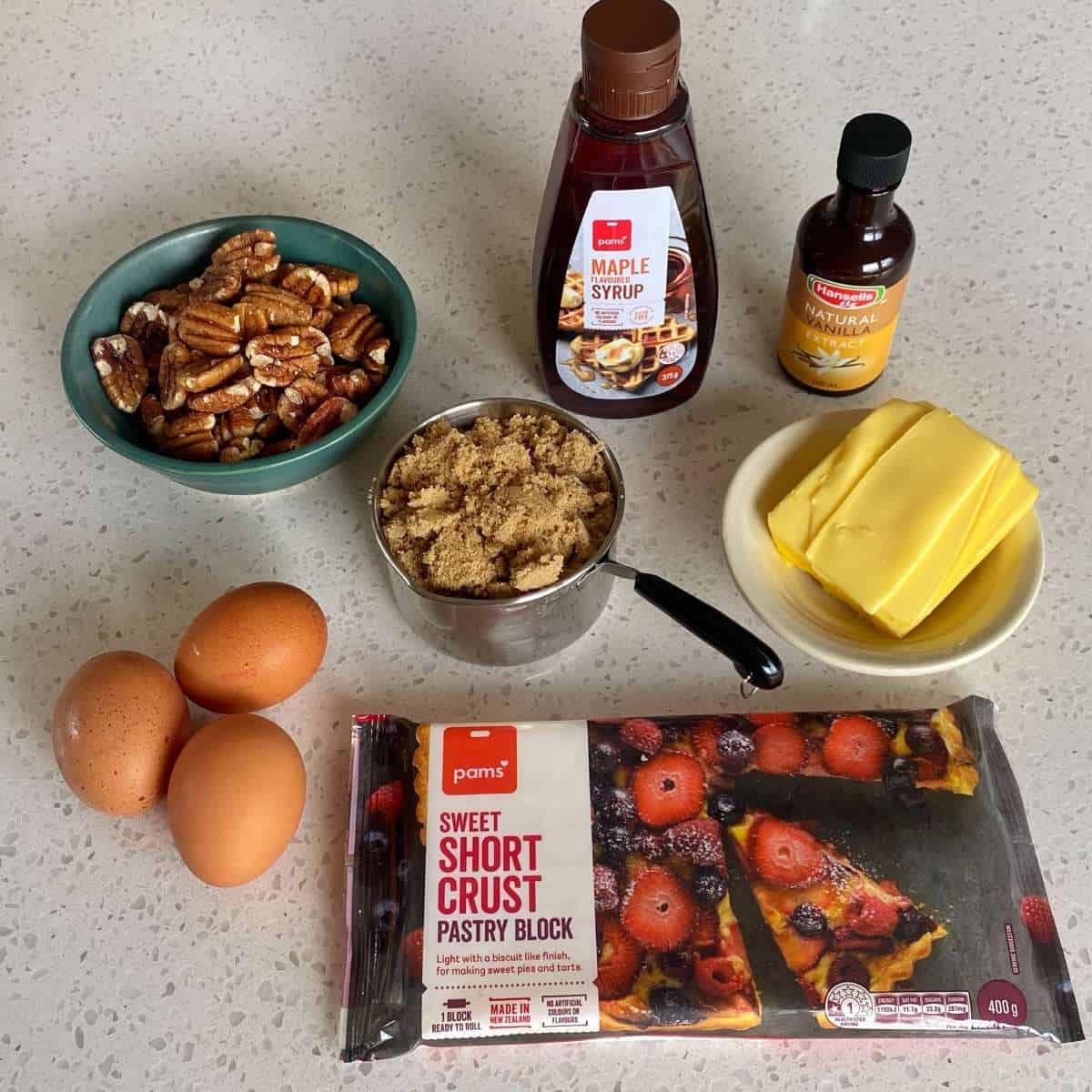 The ingredients to make pecan pie on a marble bench top