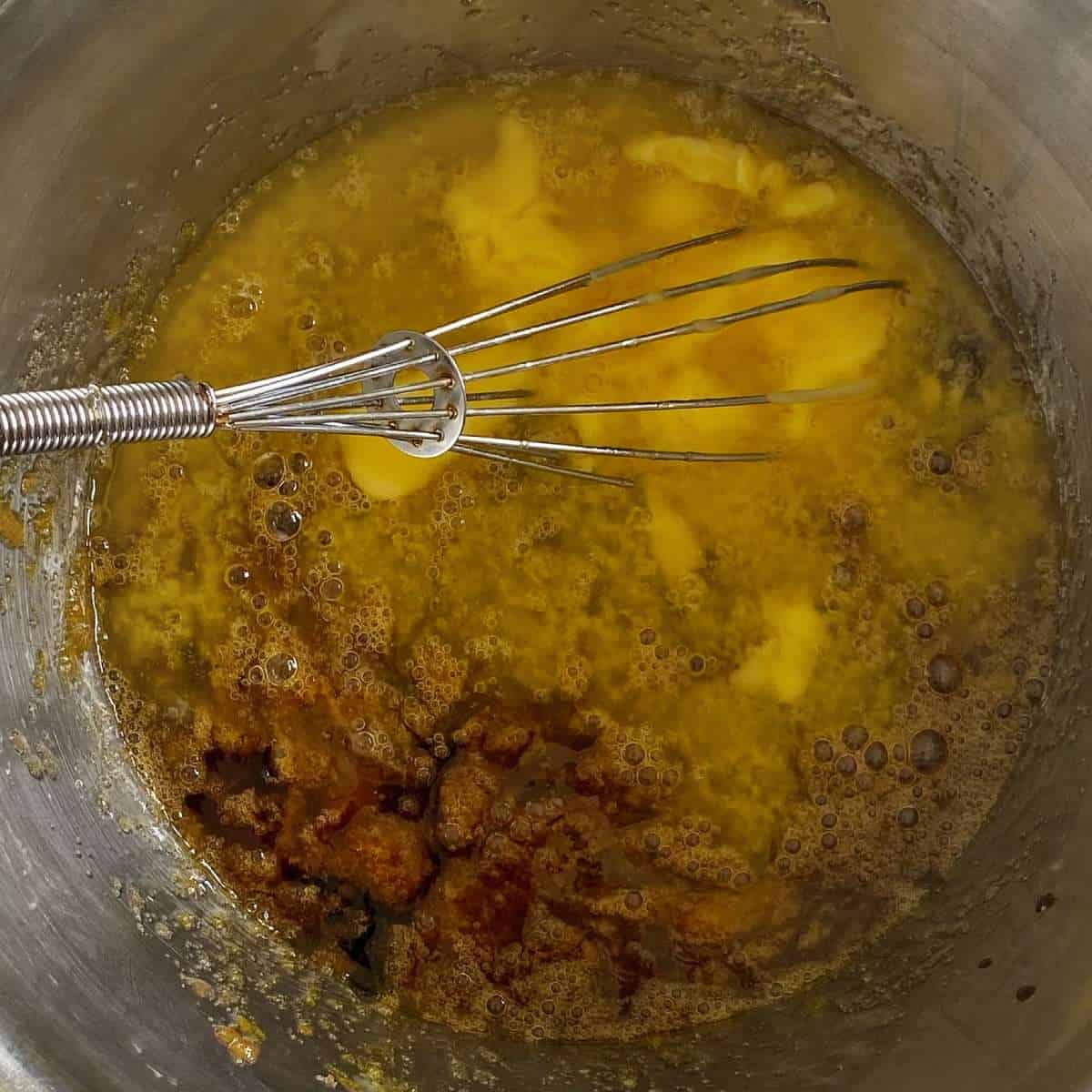 Melted butter and brown sugar in a small pot with a whisk