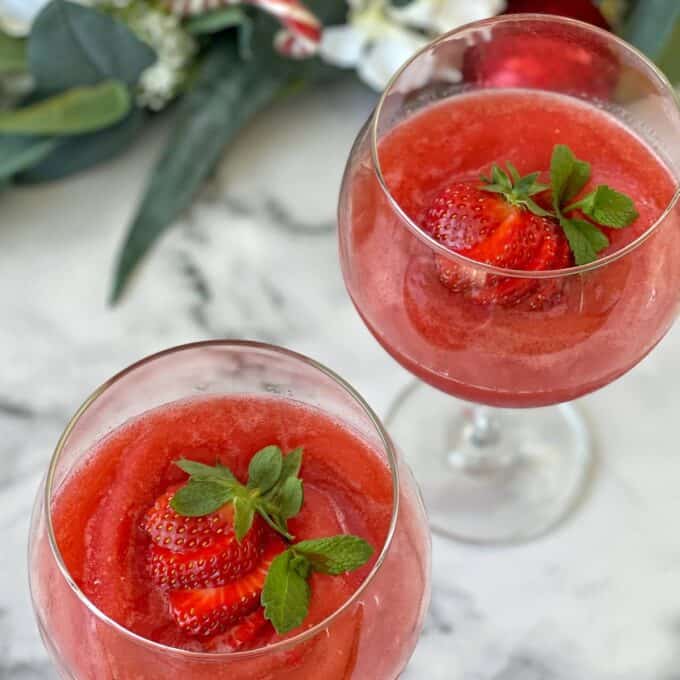 Two Strawberry Daquiri's served with a fresh strawberry in wine glasses