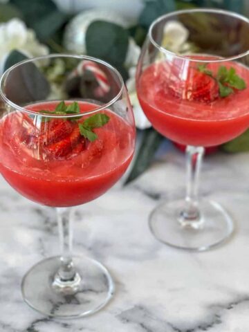 Two Strawberry Daquiri's served with a fresh strawberry in wine glasses