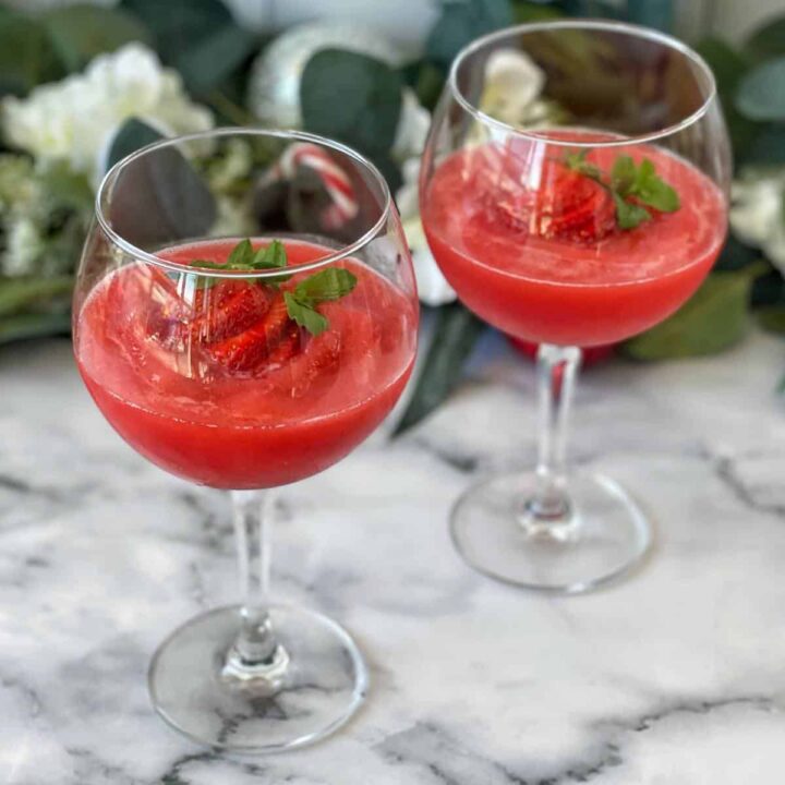 Two Strawberry Daquiri's served with a fresh strawberry in wine glasses