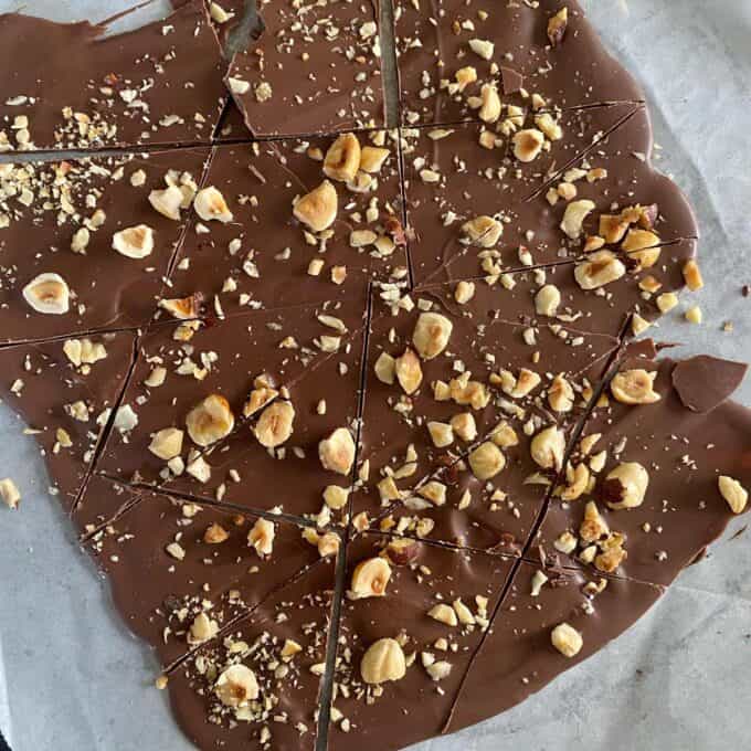 Chocolate hazelnut bark sliced into triangle pieces on a piece of baking paper.
