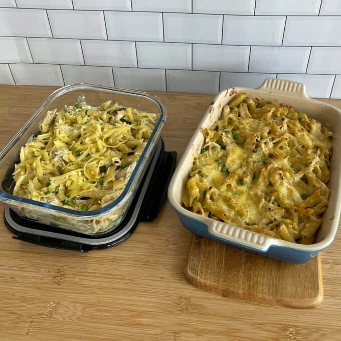Two casserole dishes on a wooden surface; the left contains uncooked pasta with vegetables, and the right contains baked pasta with melted cheese on top.